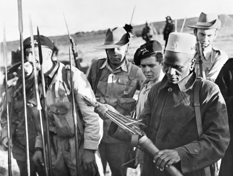 Soldiers examine spears and poisoned arrows used in the Mau Mau revolt
