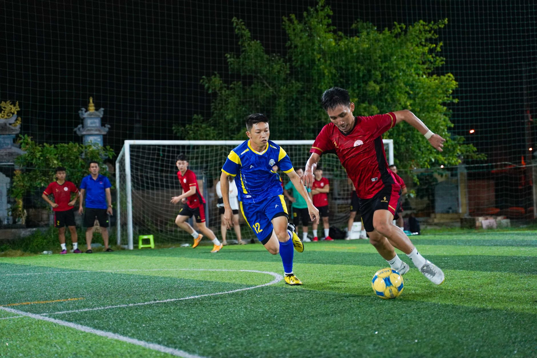 Dynamic shot of soccer players competing in a nighttime match on a turf field.