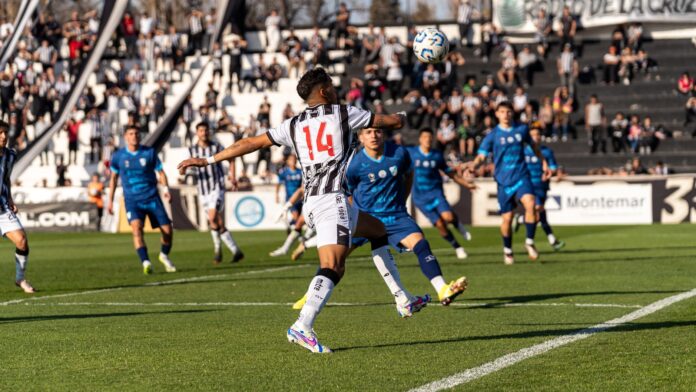Action-packed football match outdoors with dynamic players and cheering crowd in stadium.